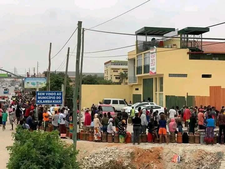 Centenas de pessoas aguardam em longas filas para comprar botijas de gás de cozinha em Angola, simbolizando a crise de distribuição energética num país rico em petróleo e gás natural.