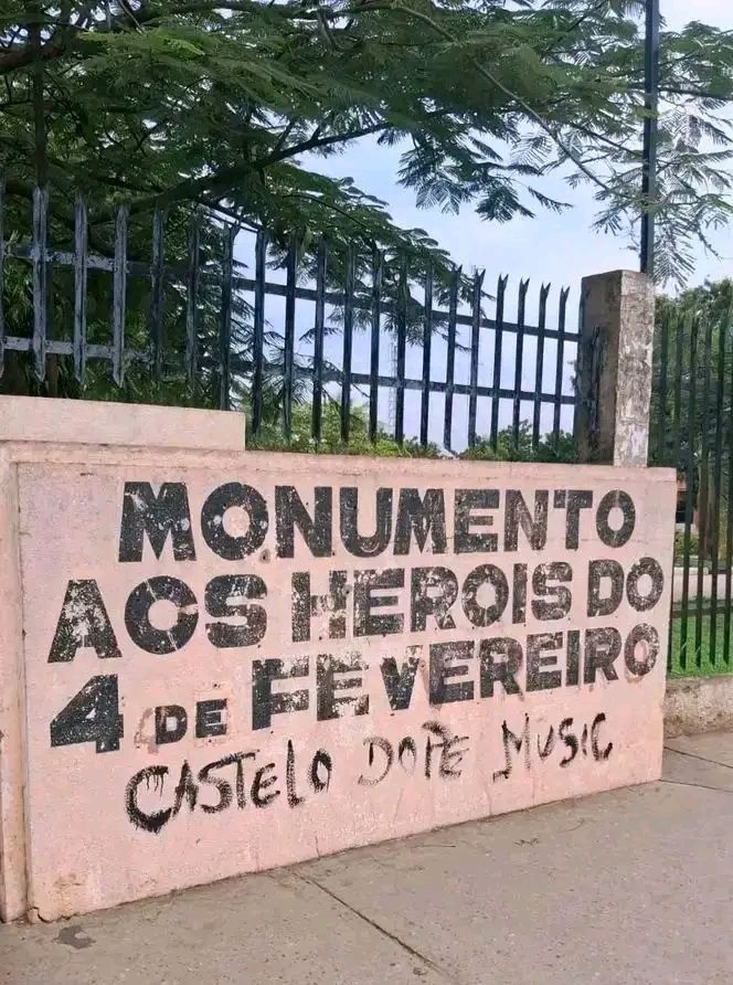 Plano aproximado da base do Monumento Marco Histórico aos Heróis do 4 de Fevereiro no Cazenga, rodeado por grandes quantidades de lixo doméstico, plásticos e detritos.