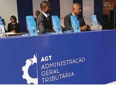 Fotografia da entrada das instalações da AGT (Administração Geral Tributária) em Angola, mostrando o logótipo oficial com uma engrenagem azul e o nome da instituição na parede