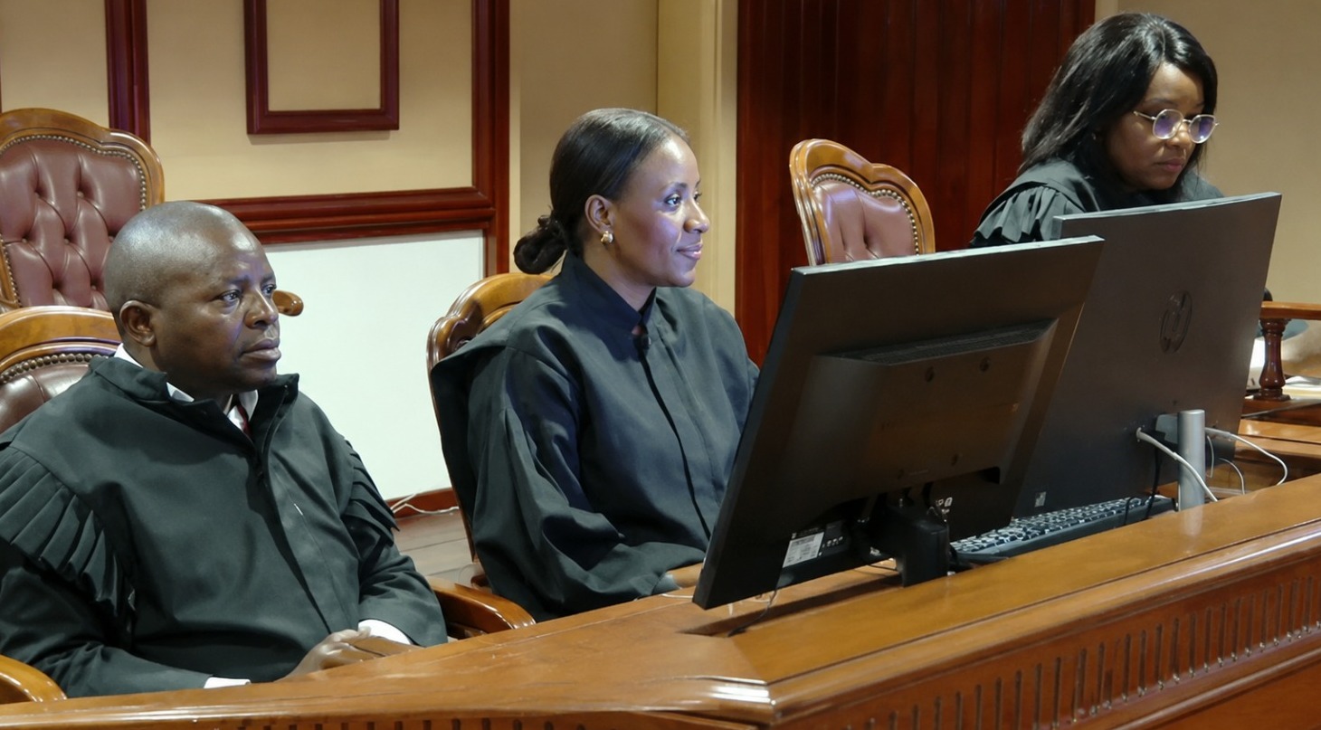 Juiz José Pereira sentado em tribunal ao lado de magistradas durante sessão de julgamento em Angola.
